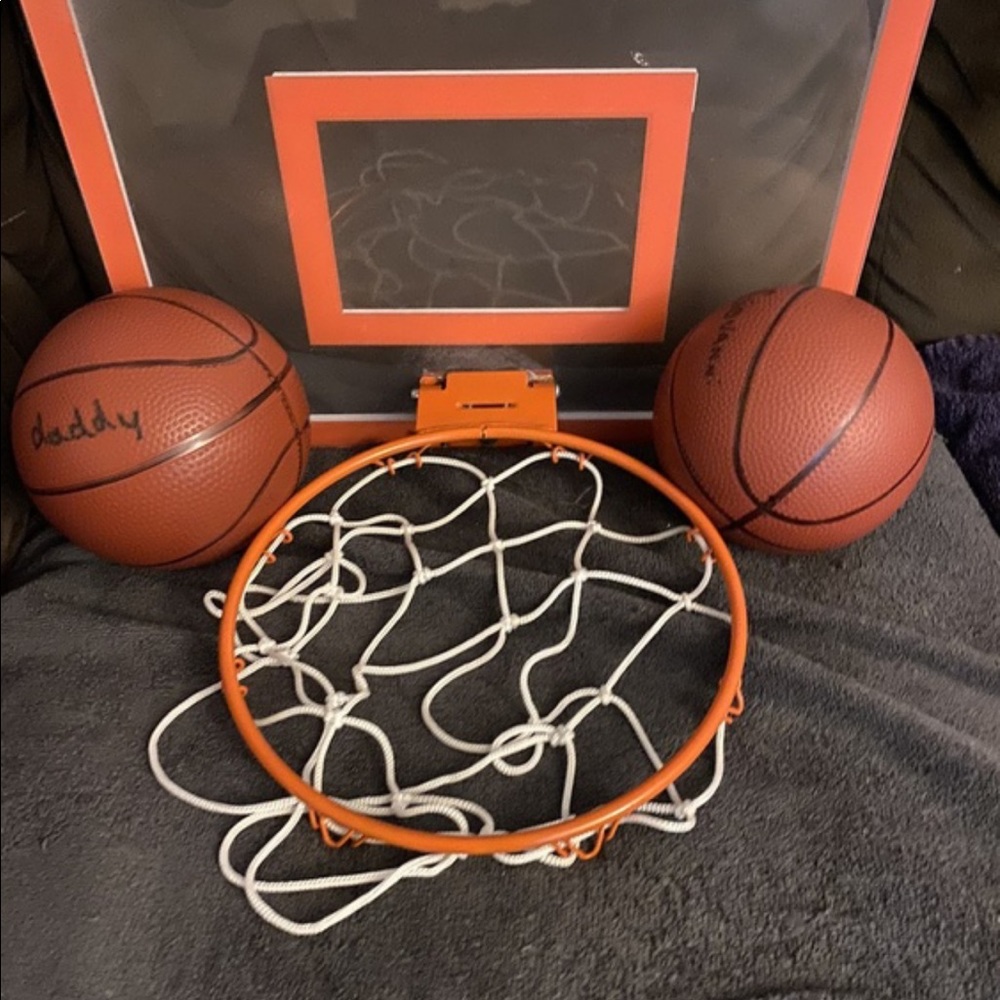 Kids door spring mounted basket ball rim with two inflated basketballs.